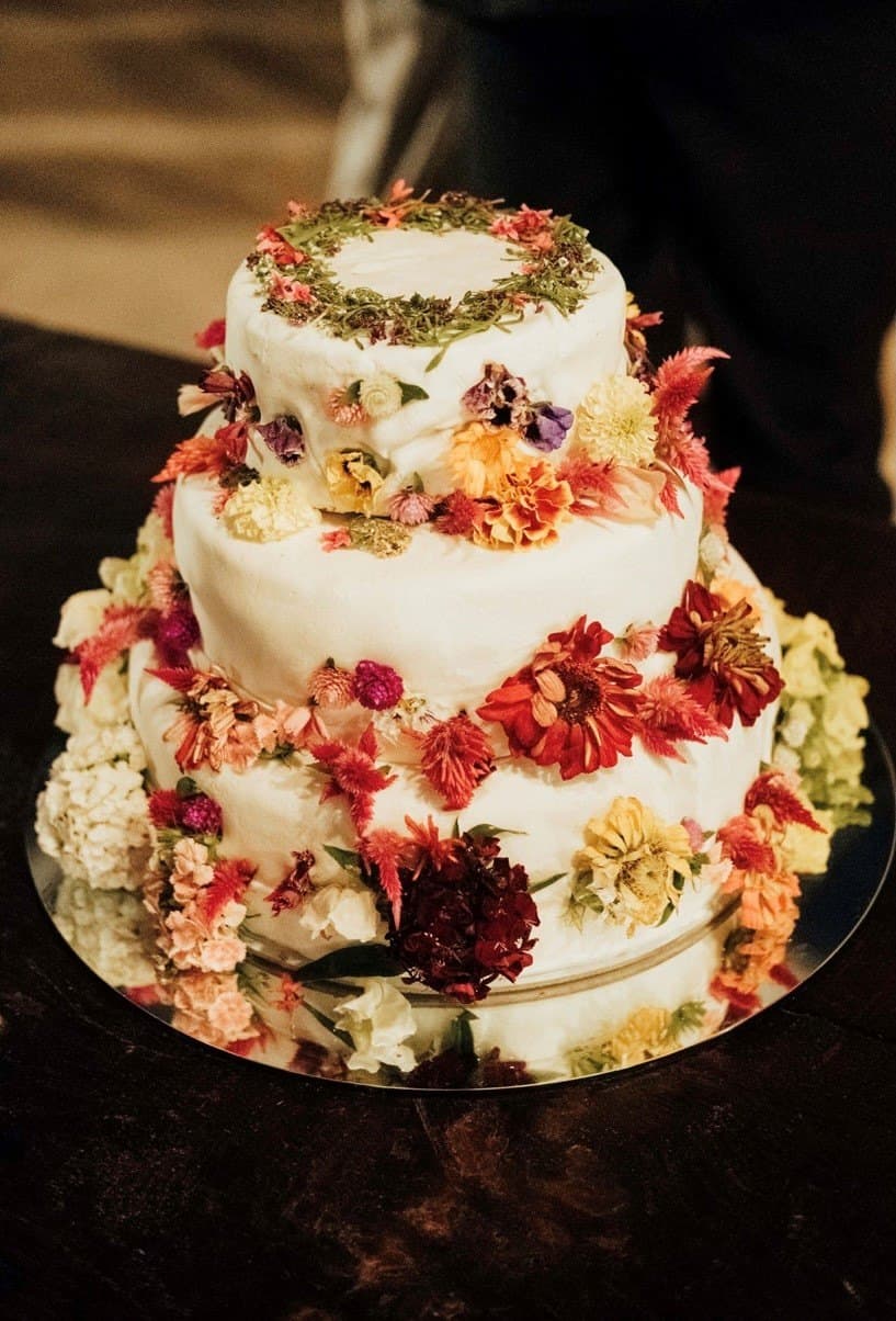 Um bolo de três andares decorado com flores.