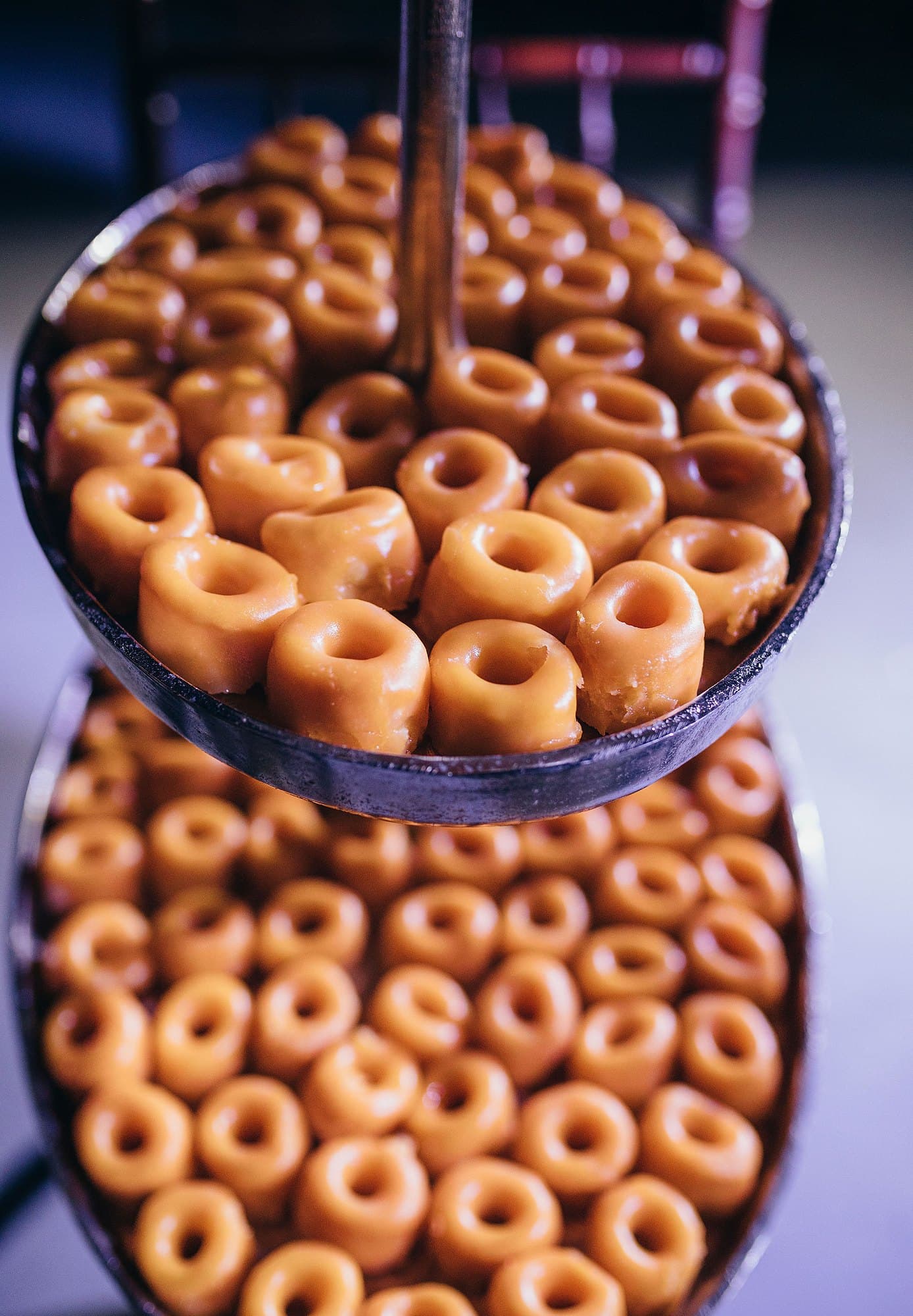 Mini donuts com cobertura de caramelo, num expositor de andares.